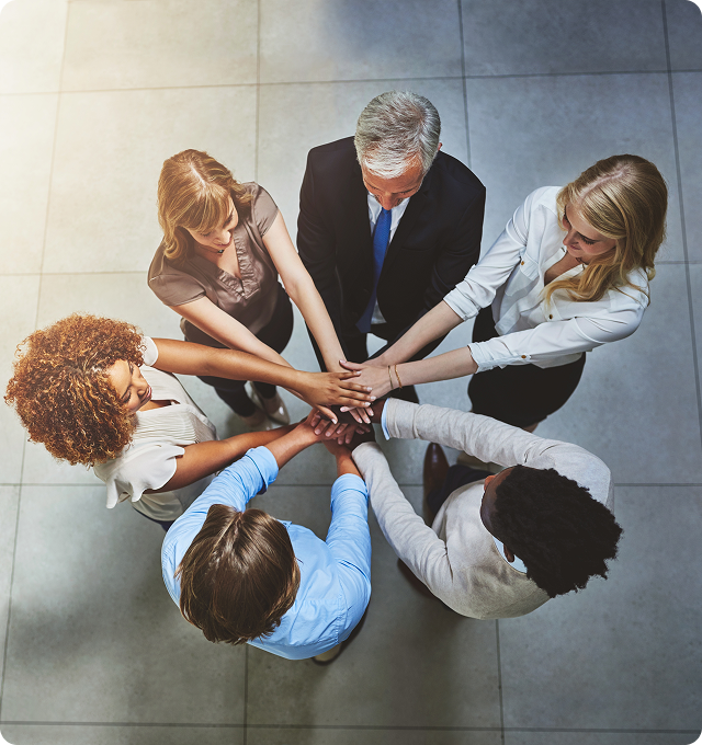 Group of people joining hands together.