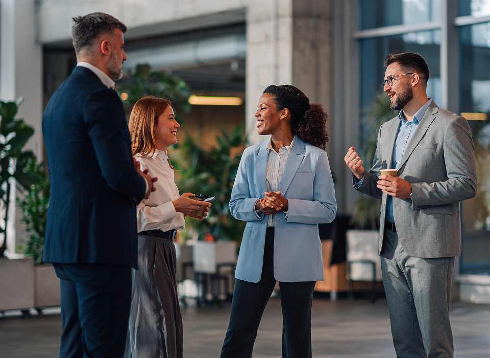 Four professionals having a conversation in office.